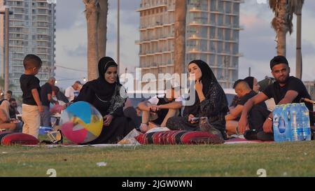 Palestinians gather at Charles Clore beachfront park during the Muslim holiday of Eid al-Adha on July 11, 2022 in Tel Aviv, Israel. Israeli authorities permitted travel for West Bank Palestinians to visit Tel Aviv and other places in Israel during Eid al-Adha holiday. Stock Photo