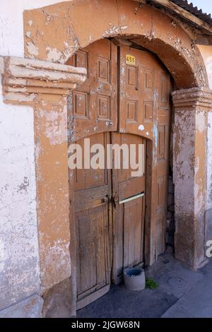 A crudely-painted wooden door in a house of traditional architecture in the small Andean mountain town of Putre, Chile. Stock Photo