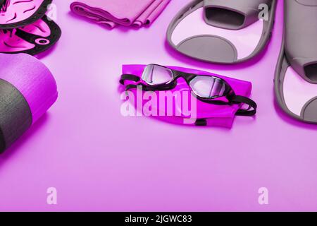 A set for swimming training in open water and in the pool on a pink background Stock Photo