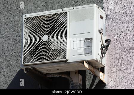 outdoor air conditioner unit with heat exchanger hanging outside the building Stock Photo