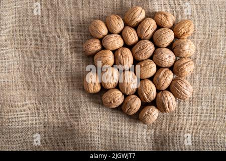 Whole walnuts on burlap sack,closeup Stock Photo