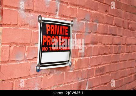 private property no trespassing sign on a brick wall in perspective angle Stock Photo