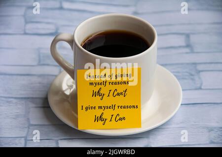Motivational quote on yellow notepad with coffee cup background - Instead of giving myself reasons why I can't, I give myself reasons why i can. Motiv Stock Photo