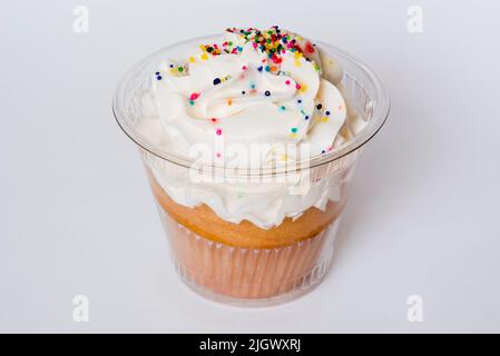 Muffin in paper wrappers inside a clear plastic wrapper isolated on white Stock Photo