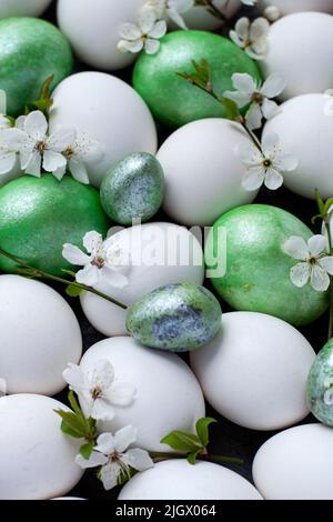 Colorful Easter eggs with spring blossom flowers isolated over white background. Stock Photo