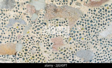 Section of the stone wall of the fortification. The texture of the stonework of a medieval building. Rough texture of pebbles and large flat stones cl Stock Photo