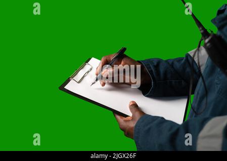 Crop seafarer making notes on clipboard Stock Photo