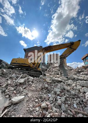 Building demolition, excavator finished building demolition. Demolishing old buildings to open new building space. Excavator with hydraulic crasher. Stock Photo