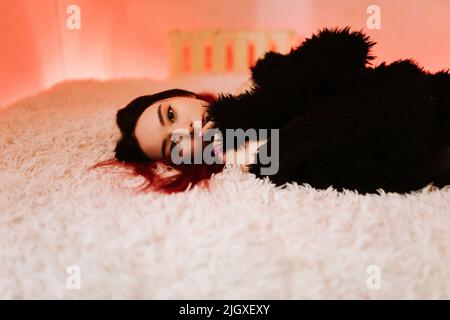 Portrait Of Beautiful Woman Lying On Bed Stock Photo