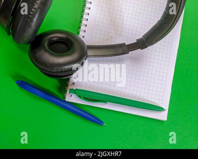 Headphones with notebook and pens Stock Photo
