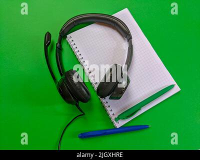 Headphones with notebook and pens Stock Photo