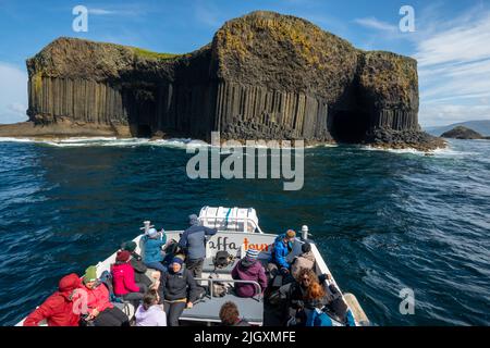 Island of Staffa (Inner Hebrides), showing entrances to the boat cave (left) and Fingal's Cave (right). Seen from a tour boat Stock Photo