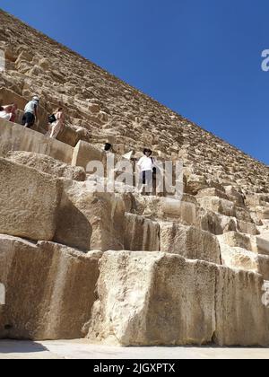 Tourists climbing on the great pyramid of Giza in Egypt, Africa Stock Photo