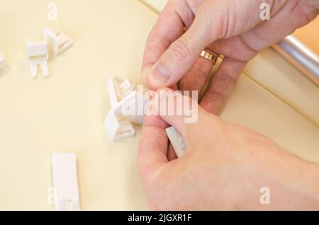 Assembly of roller blinds. Male hands are assembling roller blinds, close-up. Stock Photo