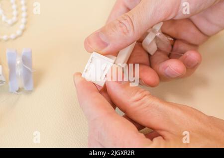 Assembly of roller blinds. Male hands are assembling roller blinds, close-up. Stock Photo