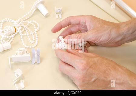 Male hands are assembling roller blinds, close-up. Assembly of roller blinds Stock Photo