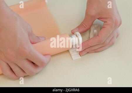 Women's hands are assembling roller blinds, close-up. Assembly of roller blinds Stock Photo