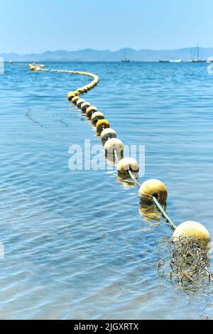 Floating buoys barrier on sea water. Safety white beacons rope for swimming  people, yachts and other ships. Copy space Stock Photo - Alamy