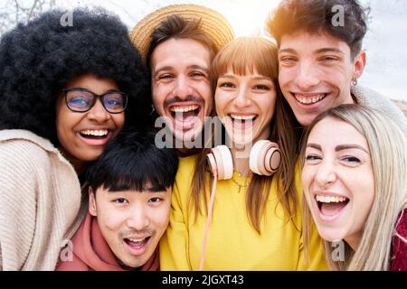 Portrait of Cheerful group of friends taking smiling selfie. Group of young students having fun together outdoors at university campus. Stock Photo