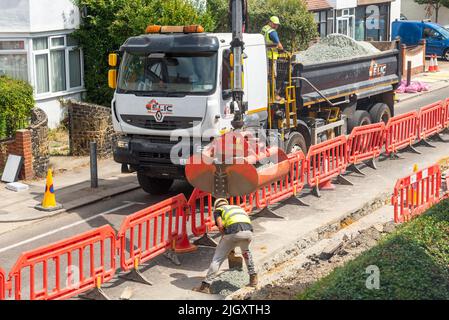 CityFibre full fibre network being installed in Southend on Sea area. Groundworks underway in residential street. Grab lorry dropping aggregates Stock Photo