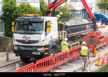 CityFibre full fibre network being installed in Southend on Sea area. Groundworks underway in residential street. Grab lorry dropping aggregates Stock Photo