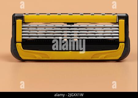 Close up of shaving razor blade cassette  isolated on brown background Stock Photo