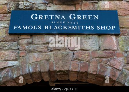 Gretna Green, Scotland - October 15th 2021: A signpost pointing visitors to the direction of the Famous Blacksmiths Shop in Gretna Green, Scotland. Stock Photo