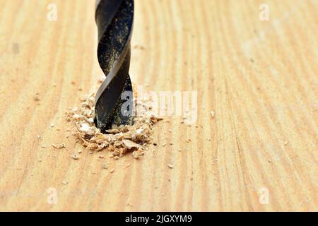 Detalle de una broca abriendo un agujero en una tabla de madera Stock Photo