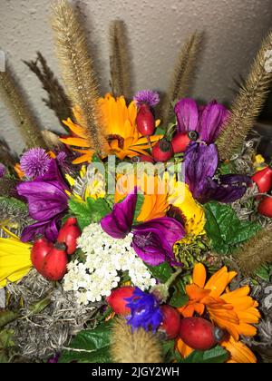 Wiesenblumen Strauß mit Malve, Hagebute, Ringelblume und Gräsern Stock Photo