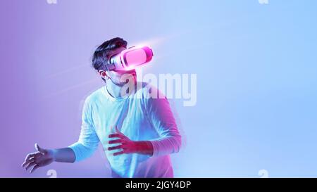 Millennial guy using modern headset, experiencing virtual reality Stock Photo