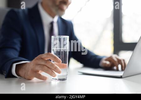 Unrecognizable Middle Aged Businessman Holding Glass Of Water While Sitting In Office Stock Photo