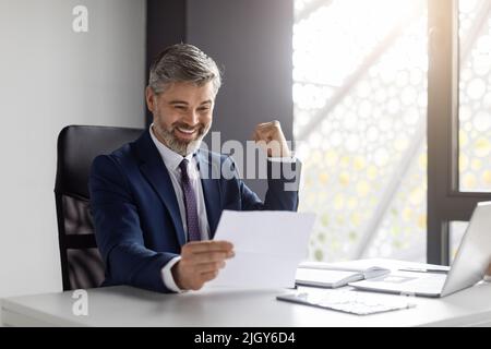 Great News. Portrait Of Happy Excited Middle Aged Businessman Reading Financial Documets Stock Photo