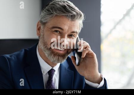 Business Call. Closeup Shot Of Smiling Mature Businessman Talking On Cellphone Stock Photo