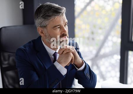 Business Planning, Portrait Of Pensive Handsome Mature Male Entrepreneur At Workplace Stock Photo