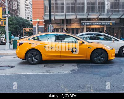An electric Tesla Model 3 New York City Yellow Cab Stock Photo