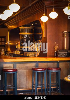 Bar table with alcohol night amusement center. Restaurant interior. Empty pub with barstools and bottles. Restaurant lobby, modern but vintage look-Jul Stock Photo