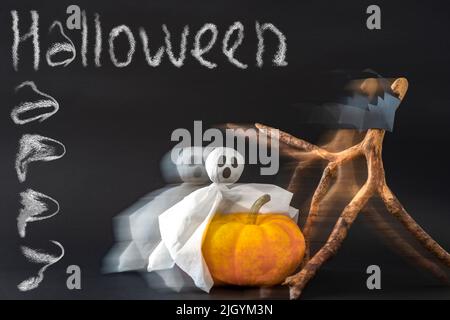 Pumpkin, ghost and bats on black background with inscription Happy Halloween with blur effect. Stock Photo