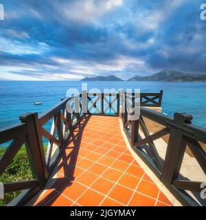 Beautiful view from balcony on blue sea, mountains and cloudy sky Stock Photo