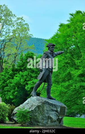 A vertical shot of the statue of General John Stark against vibrant green trees in Vermont, USA Stock Photo
