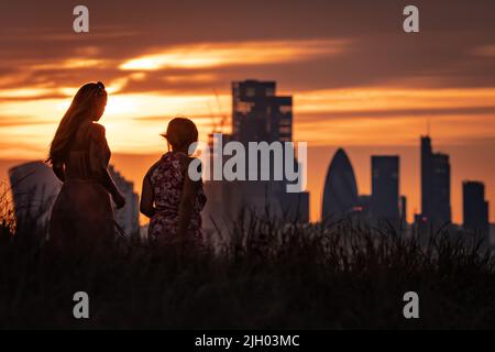 London, UK. 13th July, 2022. UK Weather: Dramatic sunset from the top of Greenwich Park as the UK's heatwave continues; an amber alert for extreme heat is in place for later this week; Britain could see its hottest day over the next week. Credit: Guy Corbishley/Alamy Live News Stock Photo