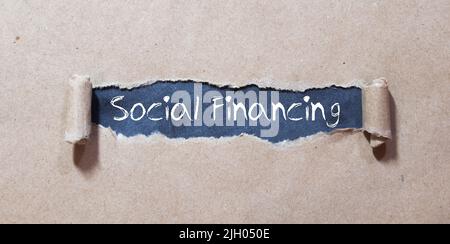 Card with text SOCIAL FINANCING on white background, near office supplies and alarm clock. Stock Photo