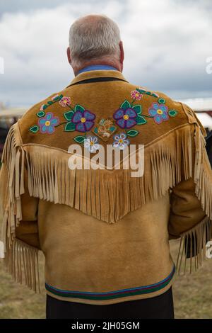 Man wearing handmade traditionally tanned and beaded moosehide jacket, in the northern Indigenous community of Deline, Northwest Territories, Canada. Stock Photo