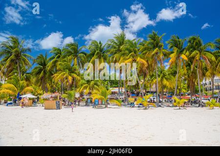 Cocos beach bar on a beach with white sand and palms on a sunny day, Isla Mujeres island, Caribbean Sea, Cancun, Yucatan, Mexico. Stock Photo