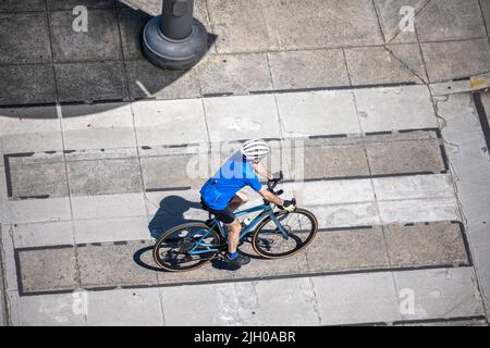 A man on a bike pedals a bicycle on a dedicated path for cyclists preferring an active healthy lifestyle using cycling ride and cycle as an alternativ