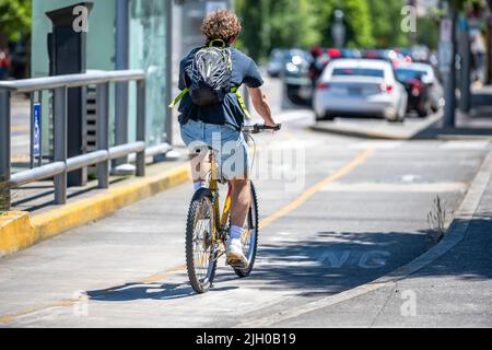 A man on a bike pedals a bicycle on a dedicated path for cyclists preferring an active healthy lifestyle using cycling ride and cycle as an alternativ