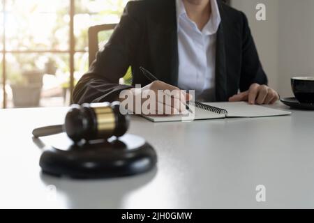 Judge gavel with Justice lawyers, Business woam in suit or lawyer working on a documents. Legal law, advice and justice concept. Stock Photo