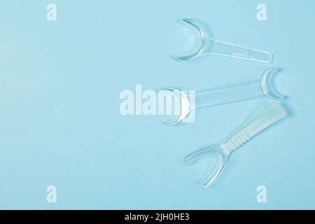 set of several Retractor Dental lip retractor Access to the oral cavity. Wide mouth opening for a dental procedure on a blue background Stock Photo