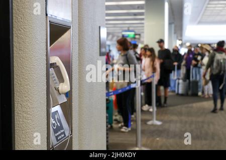 A white courtesy phone mounted on the wall of Terminal 3 at San Francisco International Airport. Stock Photo