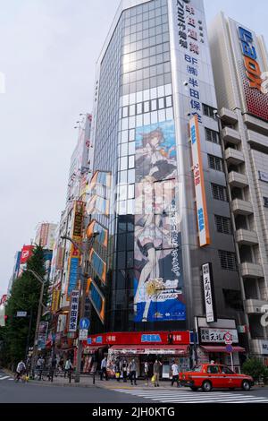 Akihabara, Japan- August 7, 2020: People walk through the town while a giant poster is hung in Akihabara. Stock Photo