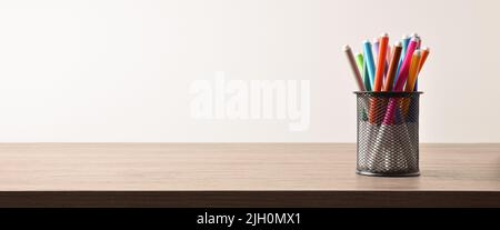 Background with group of markers of various colors in a pencil on a wooden table and white isolated background. Front view. Horizontal panoramic compo Stock Photo